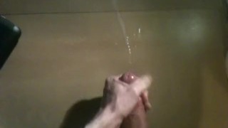 Polishing glans of huge uncut cock and shooting huge load across desk