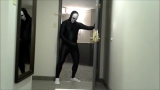 skeleton faced white socked black morphman in front of hotel room