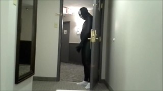 skeleton faced white socked black morphman in front of hotel room