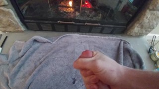 Young guy jerks off in front of fireplace on a cold day