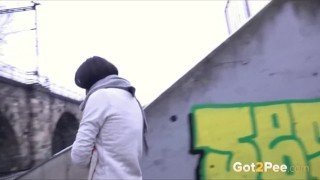 Frau pisst im Winter in einer Stadt