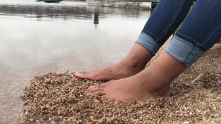 Ebony teen feet at the shore gets covered in sand.