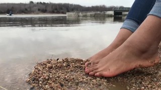 Ebony teen feet at the shore gets covered in sand.