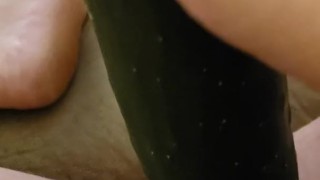 Busty woman plays with cucumber