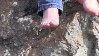 the feet of a mature lady on stones