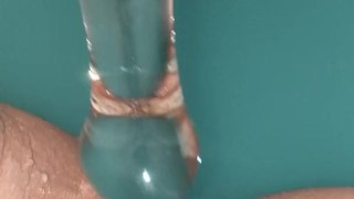 Anal play with glass in a blue bath
