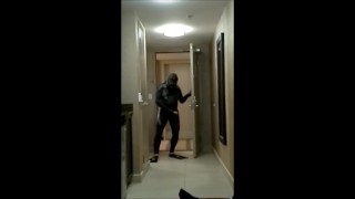 wearing wetsuit and fins shoot a quick load at open hotel door