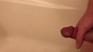 Guy pisses in the tub, then jerks himself off until he cums