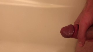 Guy pisses in the tub, then jerks himself off until he cums