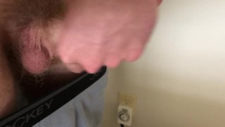 Guy pulls down his boxers and jerks off onto the floor