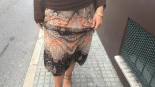 young female hippie is walking barefoot in public street