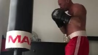 working the bag in red boxing trunks