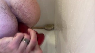 Riding red dildo in shower