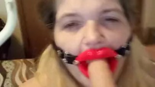Trying to talk while giving a blowjob to Dildo, wearing open mouth gag