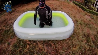 Rufus pawing off in wetsuit, fins and pool