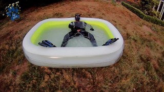 Rufus pawing off in wetsuit, fins and pool