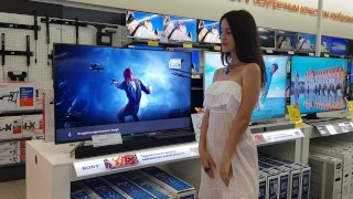The girl chooses a TV in the store and shows her pussy along the way