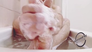 Foot massaging in the bath all wet and soapy