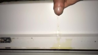 Teen piss out of a window in a entrance of apartment building - Rainy night