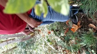 Guy taking a piss in the woods
