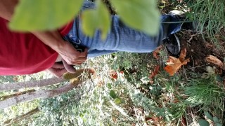 Guy taking a piss in the woods
