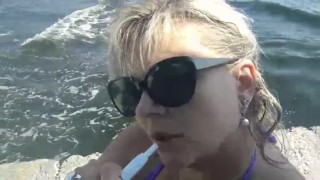 Smoke fetish on beach. Big boobs close up