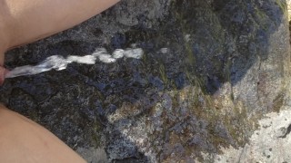Petite Girl Sits On Rock To Take A Piss
