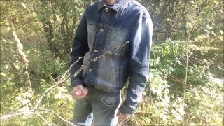 A village guy jerks off a big cock on the river bank, and fishermen swim by on a boat