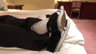 Male dress shoes, nikes, globes and white socks shoeplay in a nice hotel