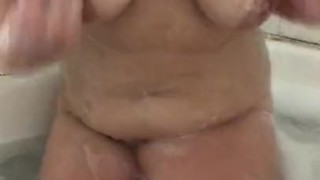 Curvy big tittied brunette plays with her pussy in bath