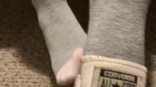 Ebony teen taking off sweaty shoes after class