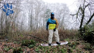 Snowboard pup pawing off outdoors