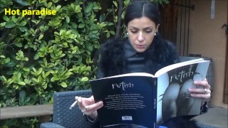 Jolie brune avec une veste en fourrure et en cuir fume une cigarette