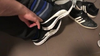 Male shoeplay in striped socks and different sneakers and watching a movie