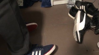 Male shoeplay in striped socks and different sneakers and watching a movie