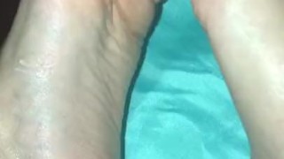 Rubbing lotion on feet and showing off soles 