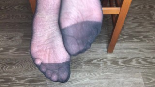 Девушка в черных вкусных носочках показывает стопы и ноги