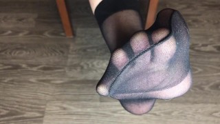 Девушка в черных вкусных носочках показывает стопы и ноги