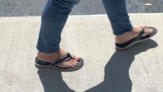 Female friend feet in flip flops coming to see me in public, in motion view