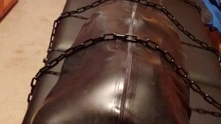 Hairless rubber gimp plugged and in chastity, training