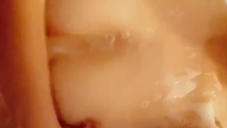 Petite teen fucks herself in the shower