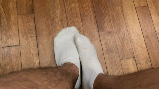Étudiant joue avec ses pieds en chaussettes blanches