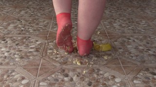 Fat legs in socks ruthlessly trample banana. Crush Fetish, foot fetish.