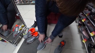 Foot fetish in a public shoe store. Fat legs try on sneakers.