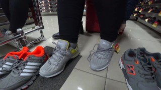 Foot fetish in a public shoe store. Fat legs try on sneakers.