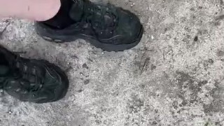 Dirty sneakers stepping on pine cones in the park
