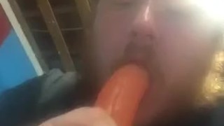 Fat guy sucking on dildo