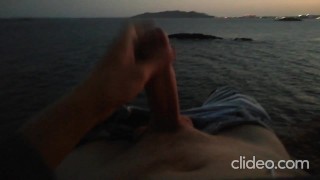 Skinny guy masturbates on a cliff during a sunset in Ibiza