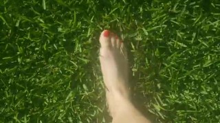 Sexy barefoot teen walks through grass 