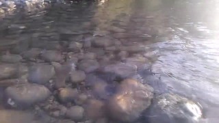 Twink with hairy pubes wanks his dick, cums on the river and his sperm floats